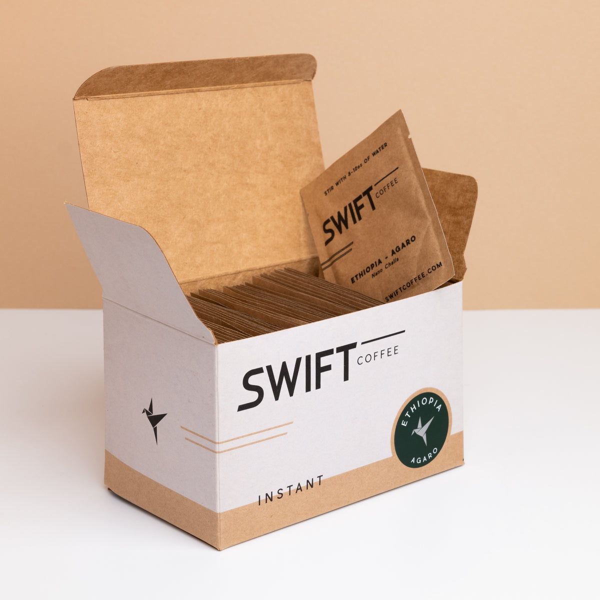 Open box of Swift Coffee Ethiopia Agaro instant coffee single-serve sachets with one sachet propped on top