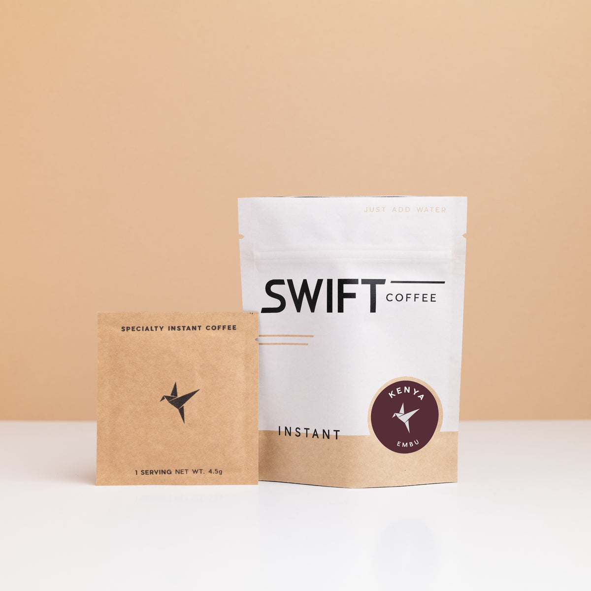 Swift Coffee Kenya – Embu instant coffee: white pouch with a maroon Kenya label and a kraft single-serve sachet
