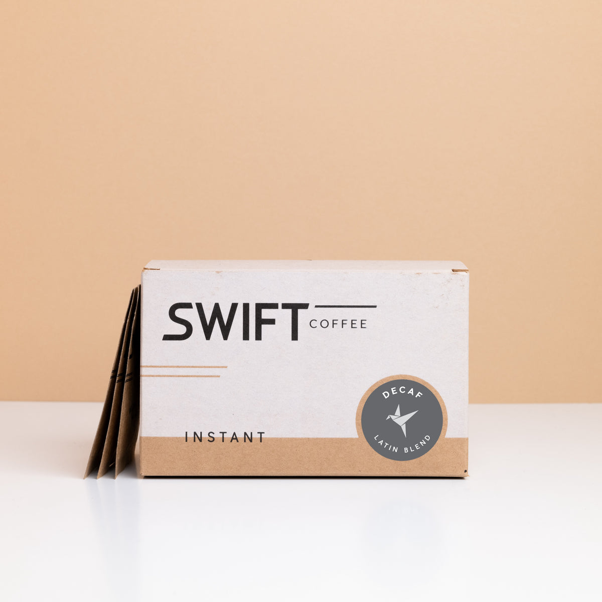 Box of Swift Coffee Decaf Latin Blend instant coffee with single-serve sachets leaning behind it