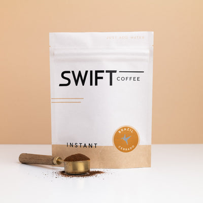 Swift Coffee Brazil Cerrado instant coffee bulk pouch with a brass scoop of instant coffee in front