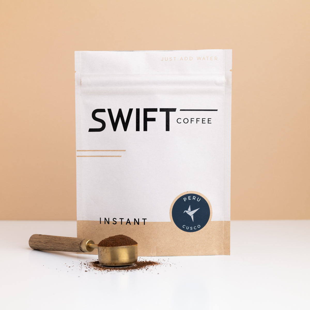 Swift Coffee Peru Cusco instant coffee pouch with a brass scoop of instant coffee in front