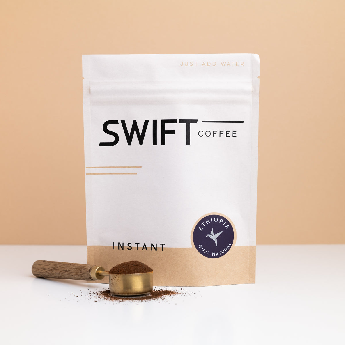 Swift Coffee Ethiopia Guji Natural instant coffee bulk pouch with a brass scoop of instant coffee in front