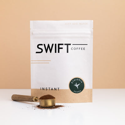 Swift Coffee Ethiopia Agaro instant coffee pouch with a brass scoop of instant coffee in front