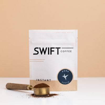 Swift Coffee Peru Cusco instant coffee pouch with a brass scoop of instant coffee in front