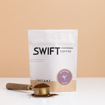 Swift Coffee Burundi Heza instant coffee bulk pouch with a brass scoop of instant coffee in front
