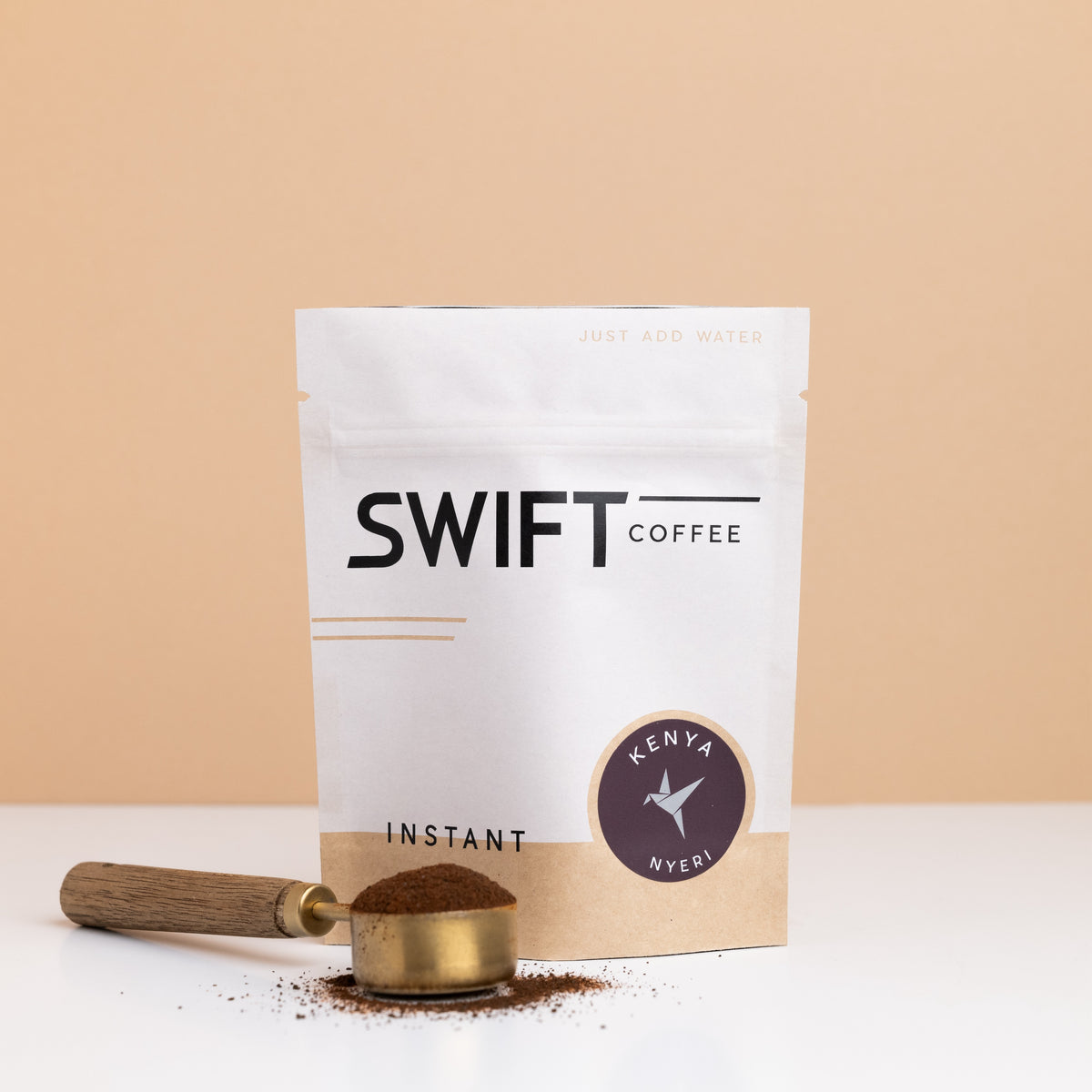 Swift Coffee Kenya Nyeri instant coffee bulk pouch with a brass scoop of instant coffee in front