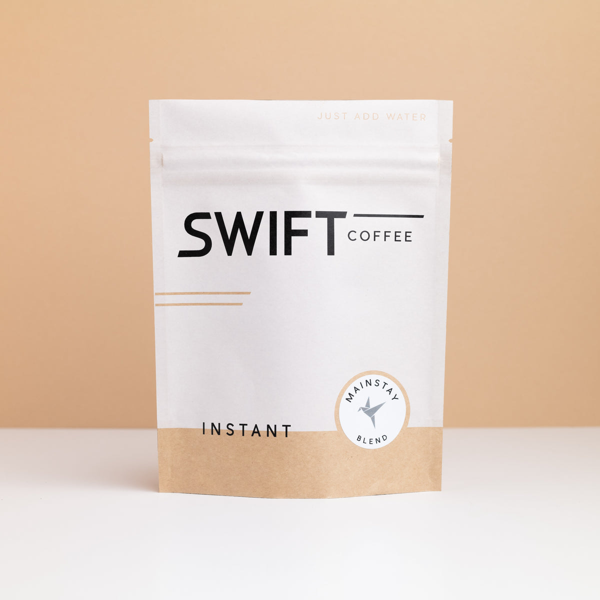 Swift Coffee Mainstay Blend instant coffee pouch on a tan backdrop