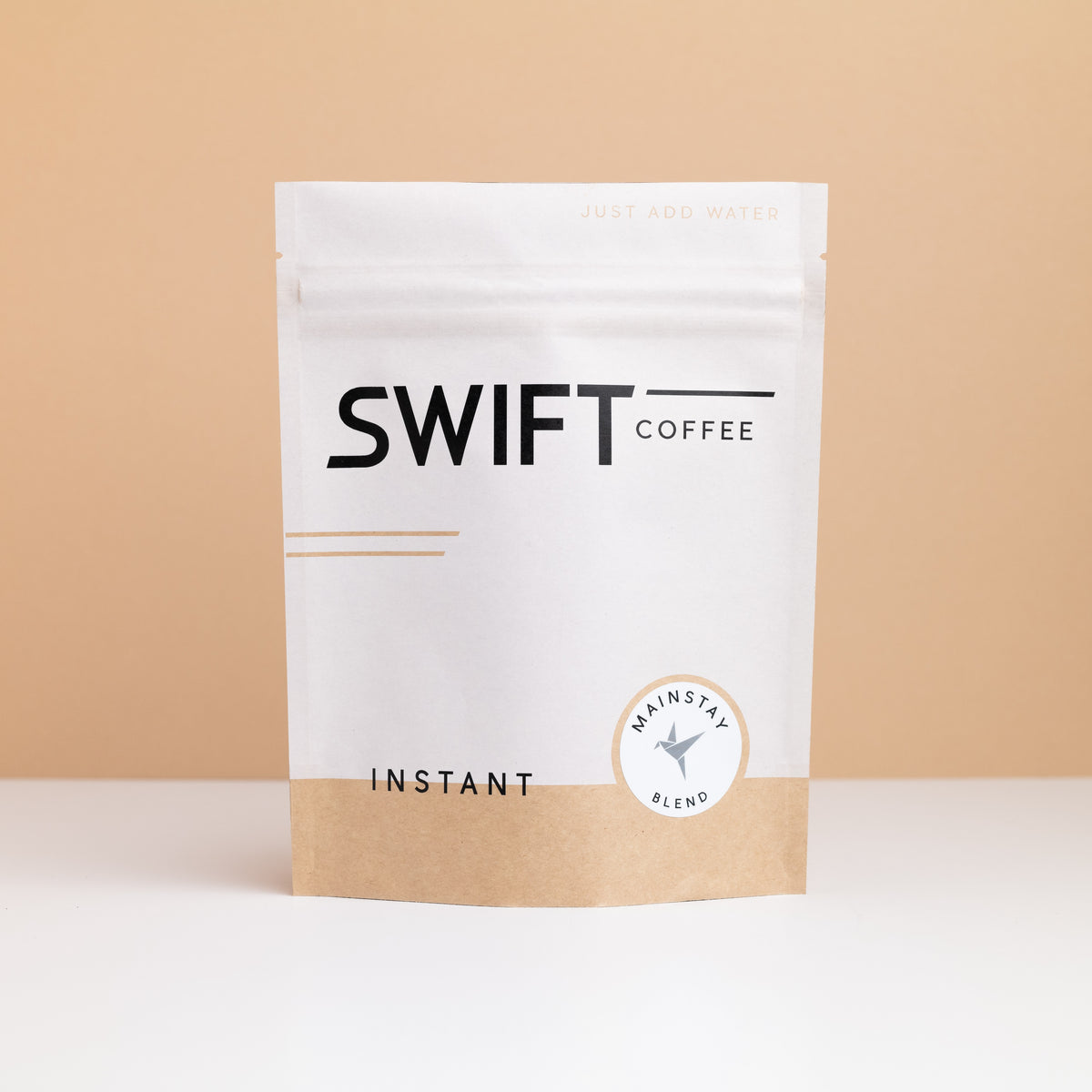 Swift Coffee Mainstay Blend instant coffee pouch on a tan backdrop