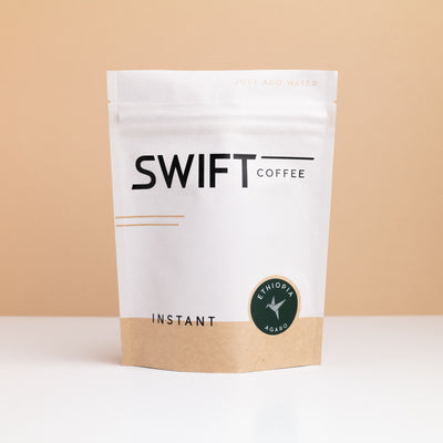 Swift Coffee Ethiopia Agaro instant coffee pouch on a tan backdrop
