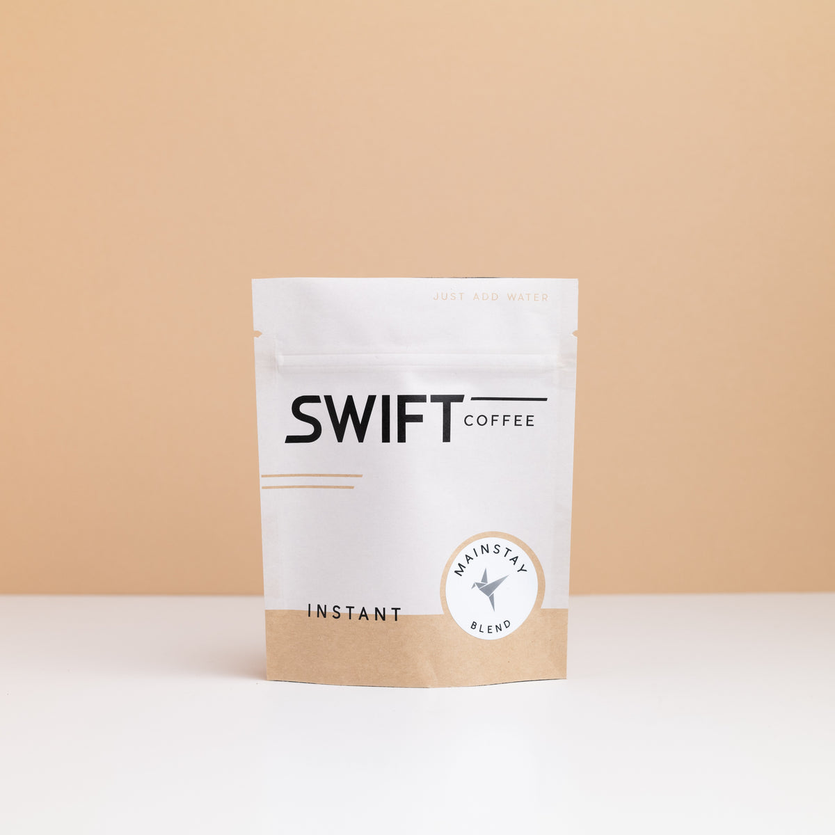 Small Swift Coffee Mainstay Blend instant coffee pouch on a tan backdrop