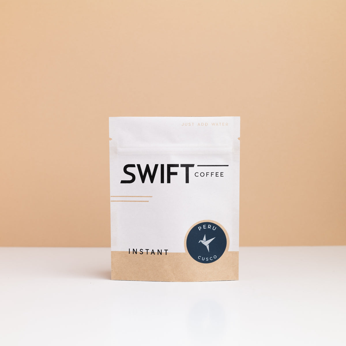 Small Swift Coffee Peru Cusco instant coffee pouch on a tan backdrop