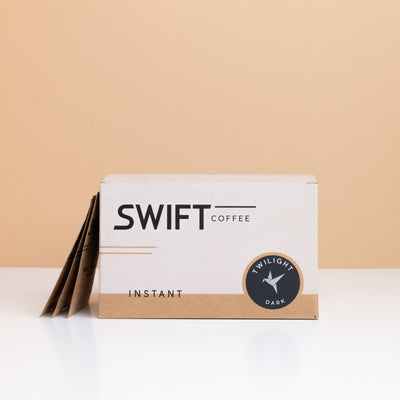 Box of Swift Coffee Twilight Dark Roast instant coffee with single-serve sachets leaning behind it