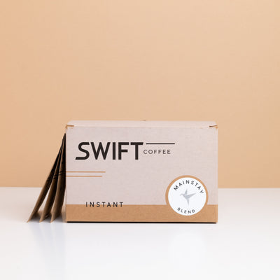 Box of Swift Coffee Mainstay Blend instant coffee with single-serve sachets leaning behind it