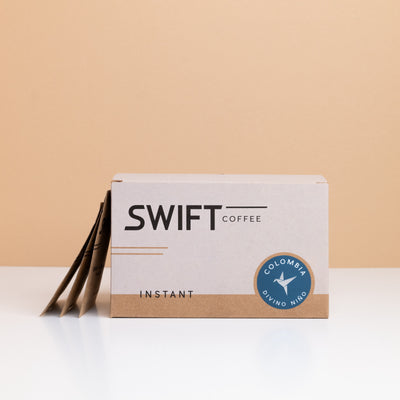 Box of Swift Coffee Colombia Divino Nino instant coffee with single-serve sachets leaning behind it