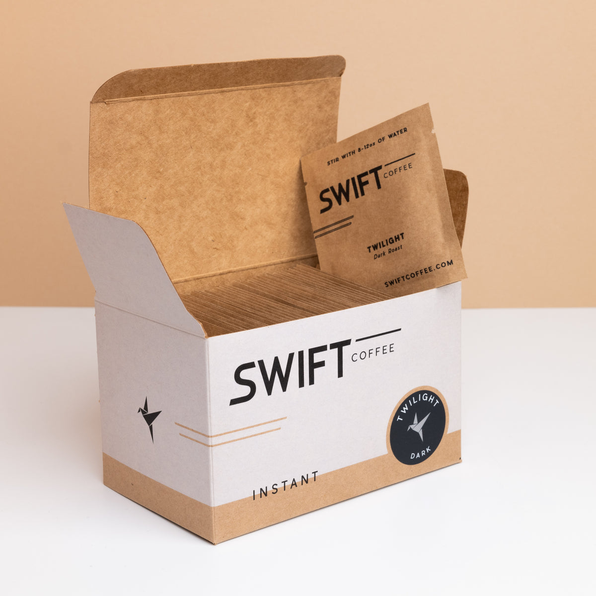 Open box of Swift Coffee Twilight Dark Roast instant coffee single-serve sachets with one sachet propped on top