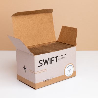 Open box of Swift Coffee Mainstay Blend instant coffee, filled with kraft single-serve sachets