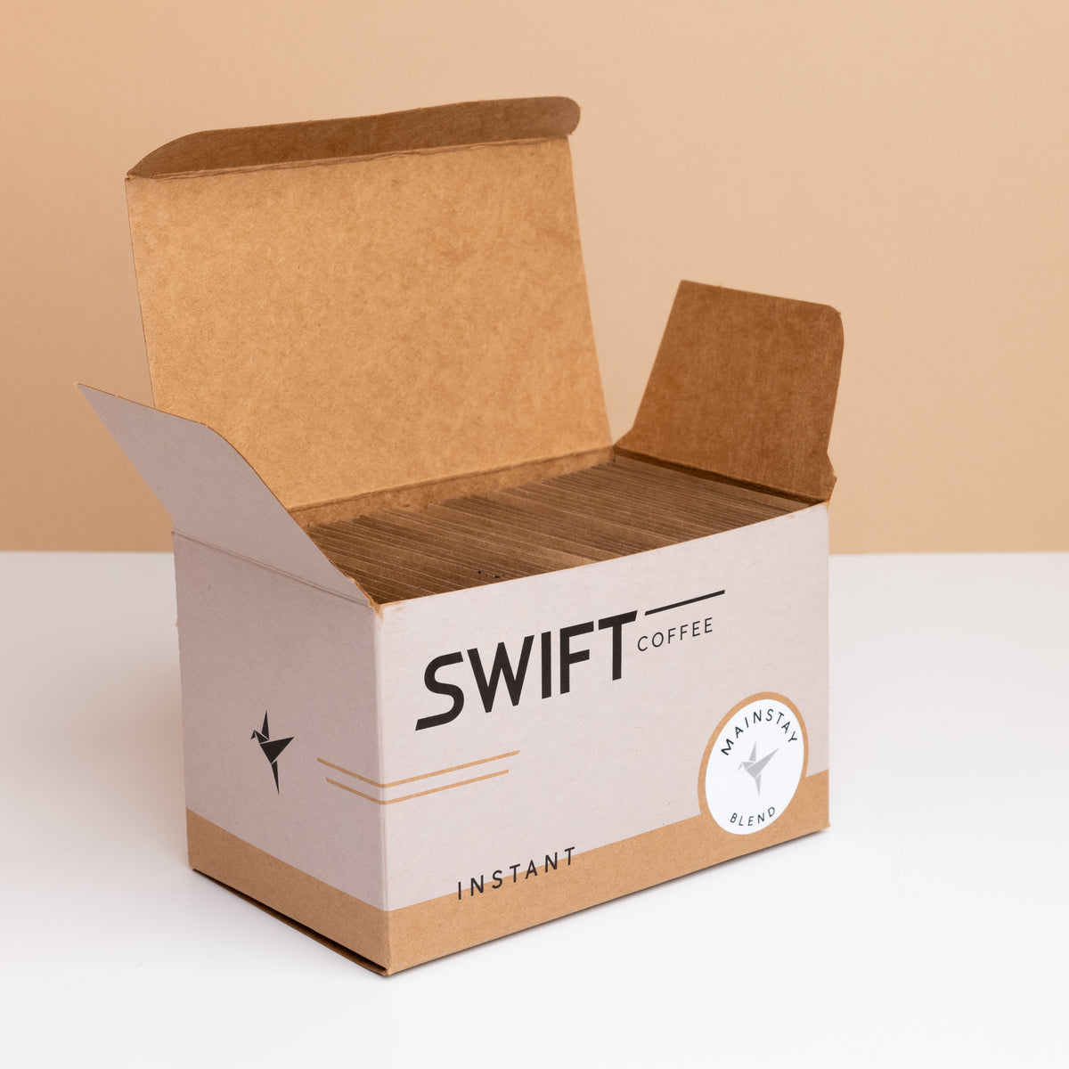 Open box of Swift Coffee Mainstay Blend instant coffee, filled with kraft single-serve sachets