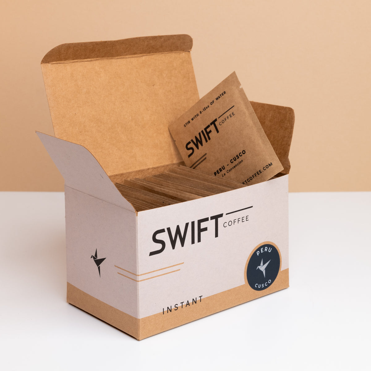 Open box of Swift Coffee Peru Cusco instant coffee single-serve sachets with one sachet propped on top