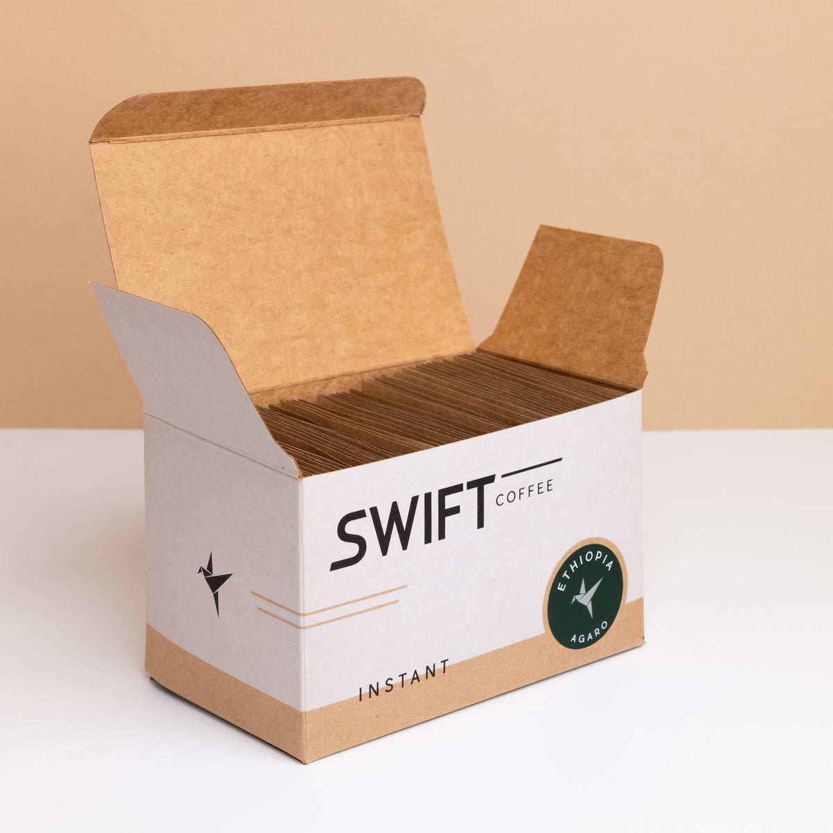 Open box of Swift Coffee Ethiopia Agaro instant coffee, filled with kraft single-serve sachets