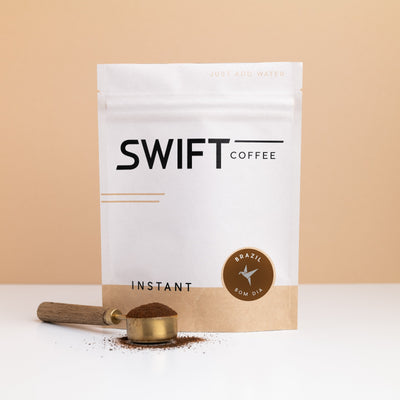 Swift Coffee Brazil Bom Dia instant coffee pouch with a brass scoop of instant coffee in front