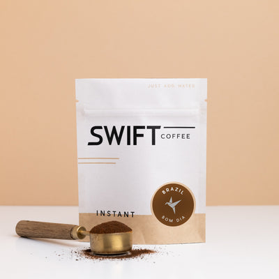 Swift Coffee Brazil Bom Dia instant coffee pouch with a brass scoop of instant coffee in front