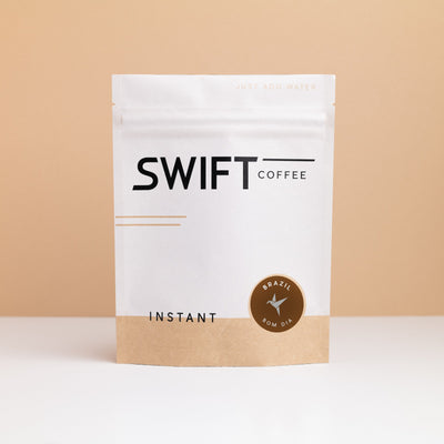 Swift Coffee Brazil Bom Dia instant coffee pouch on a tan backdrop