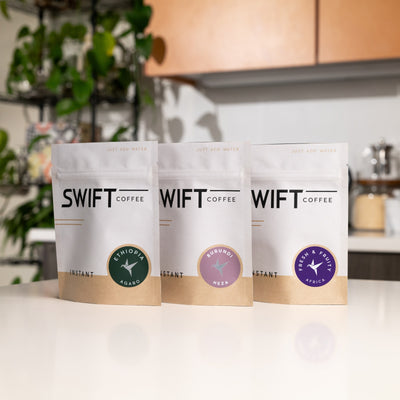 Swift Coffee East Africa Trio on a kitchen counter: Ethiopia Agaro, Burundi Heza and Fresh & Fruity Africa instant coffee pouches