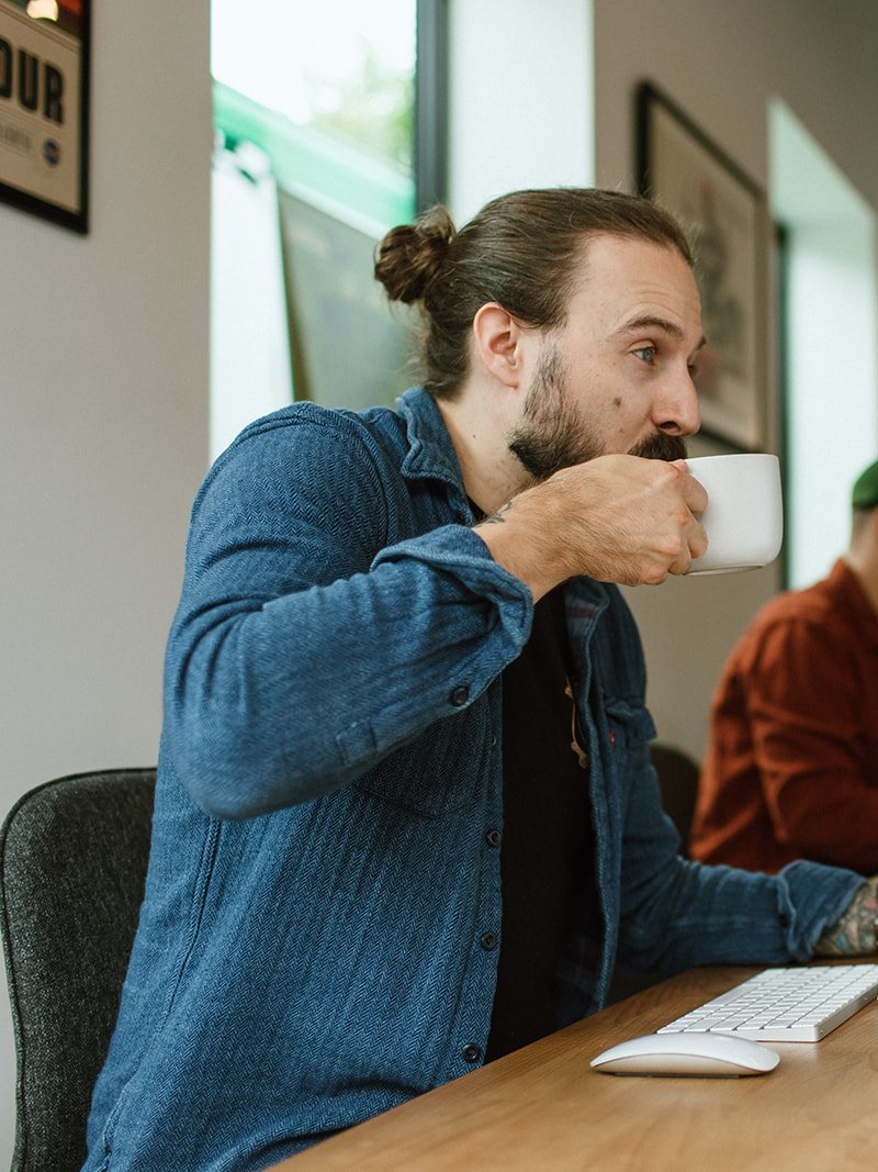 Coffee at the desk in a bright tech office
