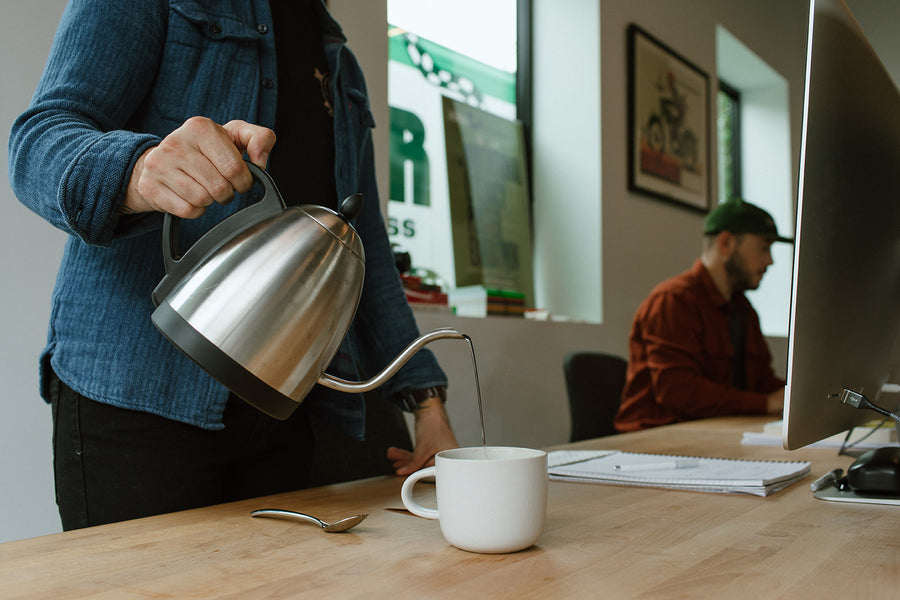 Kettle pour into a mug at a tech office desk