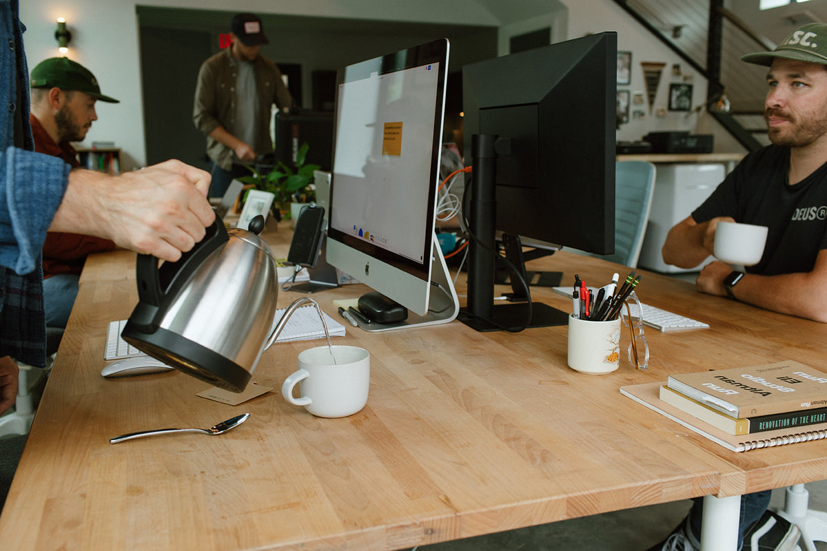 Pouring hot water for Swift instant coffee at an office desk