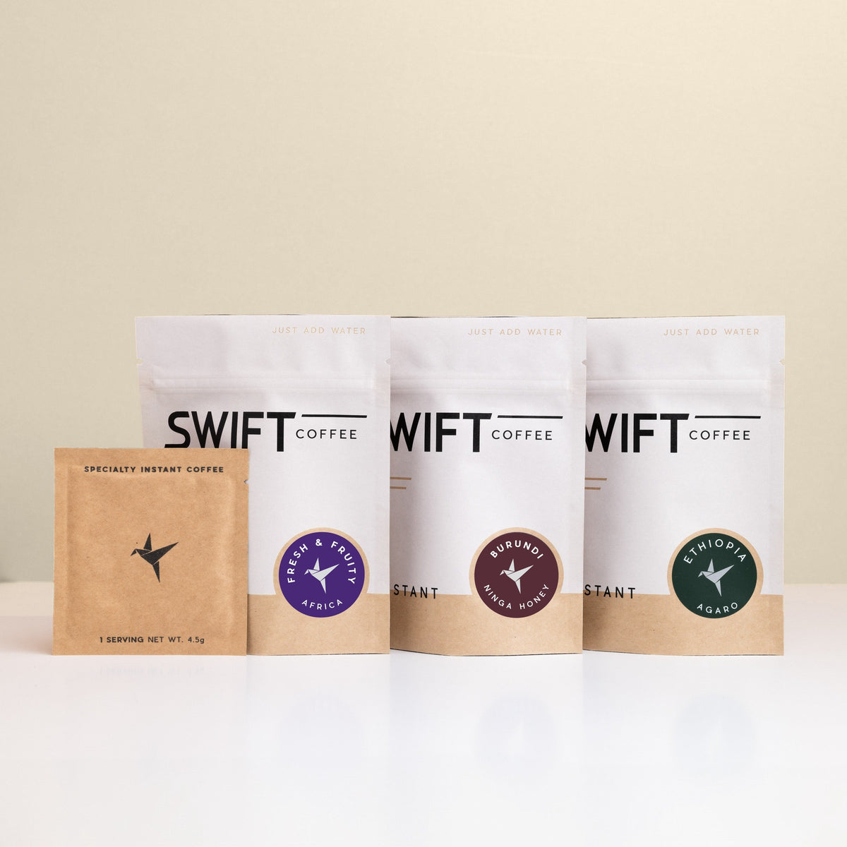Swift Coffee East Africa Trio instant coffee pouches on an oat background