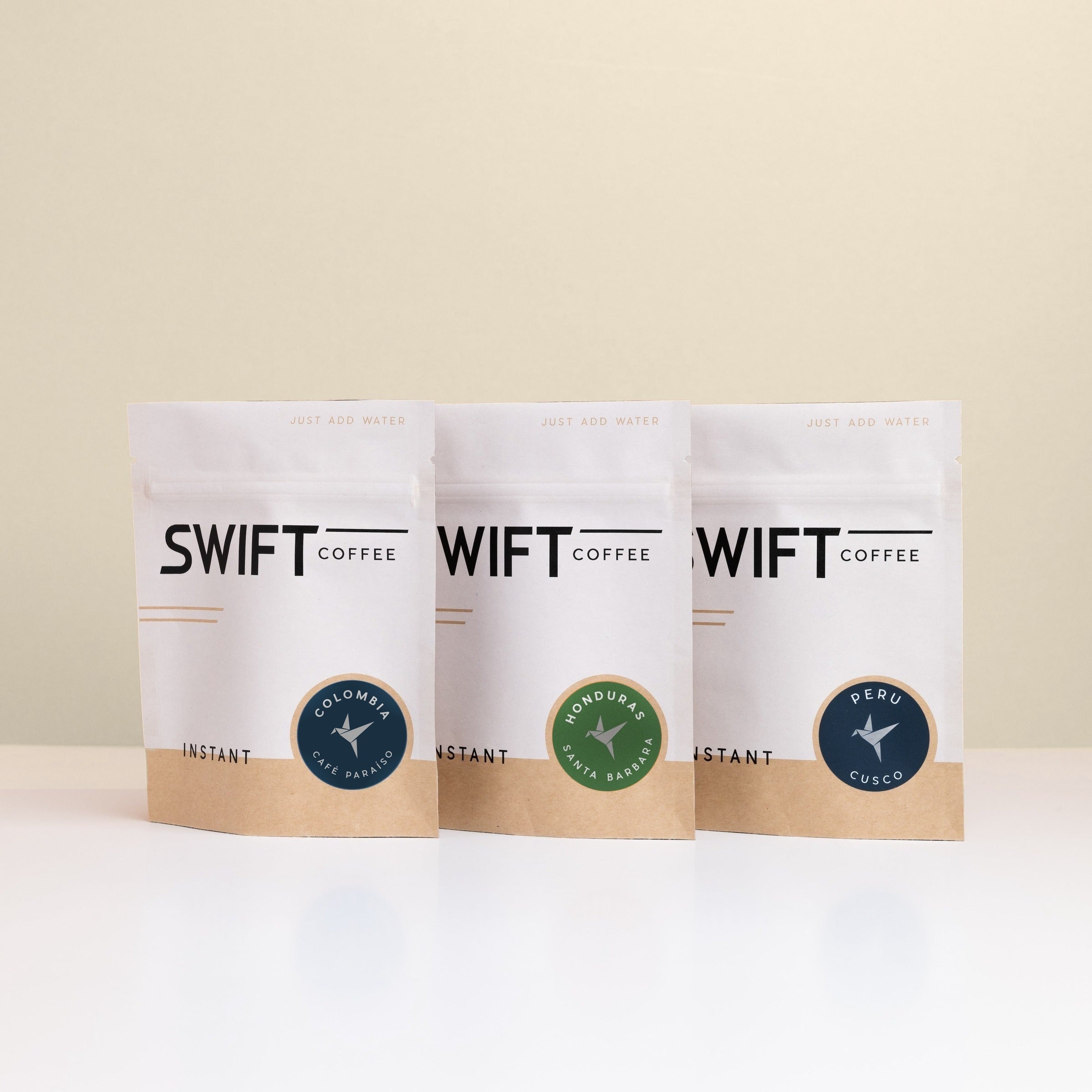 Swift Coffee Latin American Trio instant coffee pouches on an oat background