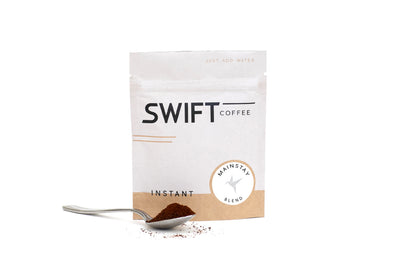 Swift Coffee Mainstay Blend instant coffee pouch with a spoonful of instant coffee, on a white background