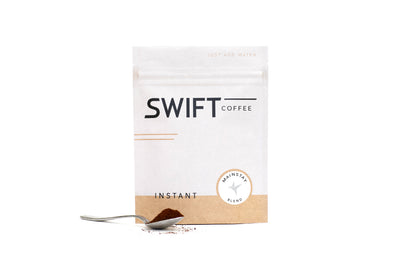 Swift Coffee Mainstay Blend instant coffee pouch with a spoonful of instant coffee, on a white background